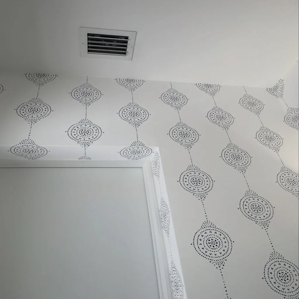 A wallpaper installer mid-job at a residential site, caught rather than posed, the kind of everyday moment a small company posts from a phone